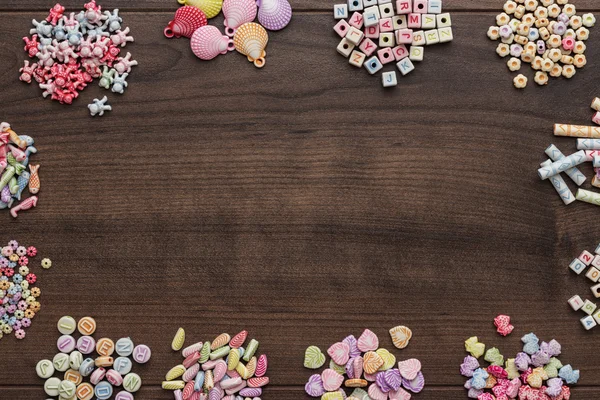 Different colorful beads on the brown wooden table — Stock Photo, Image