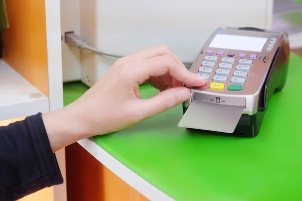 Hand inserts a credit card into the device for calculation — Stock Photo, Image