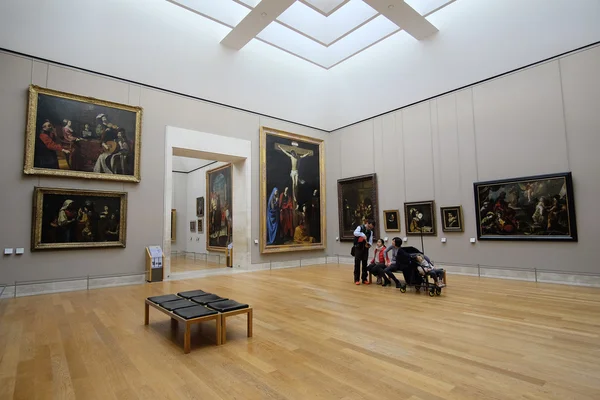 Besökarna tittar på bilderna i Louvren — Stockfoto