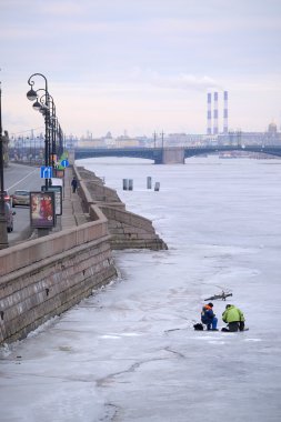 Balıkçı bir buz St. Petersburg Neva Nehri'nin üzerinde