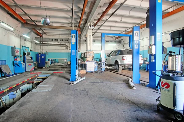 Auto op een lift in een auto reparatie station — Stockfoto