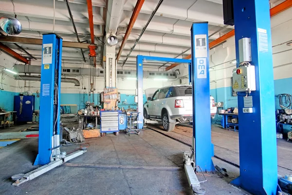 Auto su un ascensore in una stazione di riparazione auto — Foto Stock