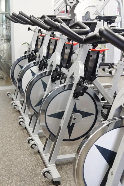 Moderna sala de fitness com as bicicletas de exercício — Fotografia de Stock