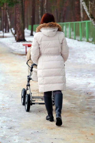 Young mother pushing pram — Stock Photo, Image