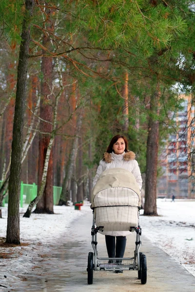 Young mother is walking in the park with her baby — Stock Photo, Image