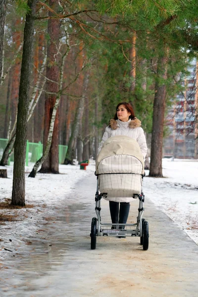 Young mother is walking in the park with her baby — Stock Photo, Image