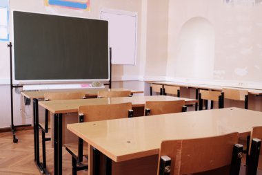 Çalışma masaları ve bir tahta ile sınıf