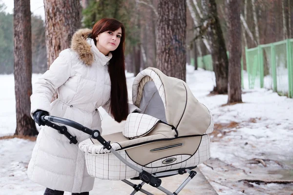 Ung mamma promenader i parken med sin baby — Stockfoto