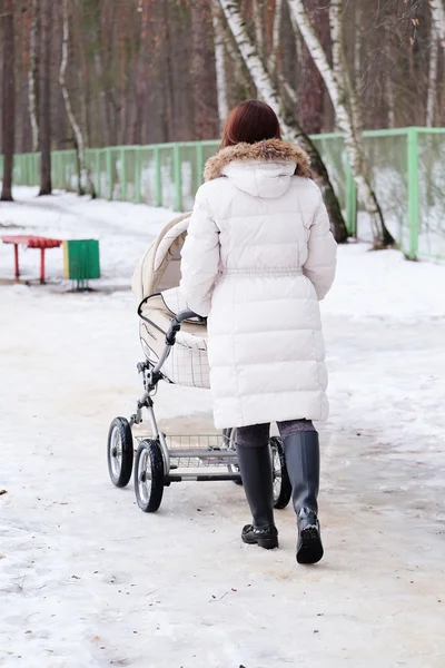 Young mother is walking in the park with her baby — Stock Photo, Image