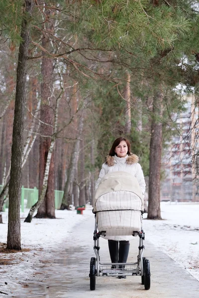 Young mother is walking in the park with her baby — Stock Photo, Image