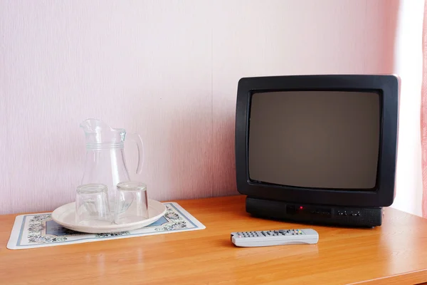 TV en de afstandsbediening op de tafel — Stockfoto