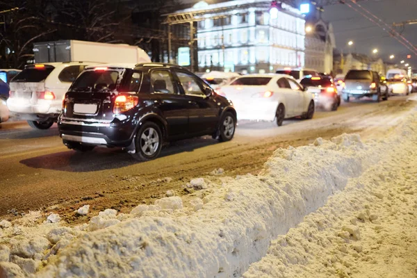 Auta na zasněžené silnici v ulici — Stock fotografie