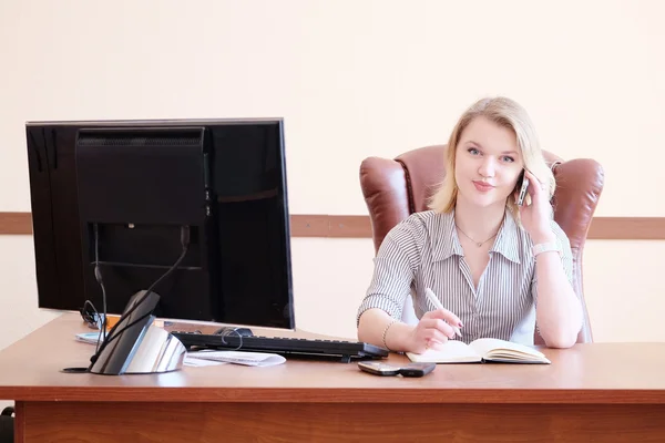 Lachende blonde secretaresse in het kantoor — Stockfoto