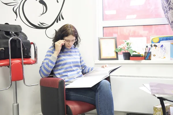 Woman client reading magazine in hairdressing — Stock Photo, Image