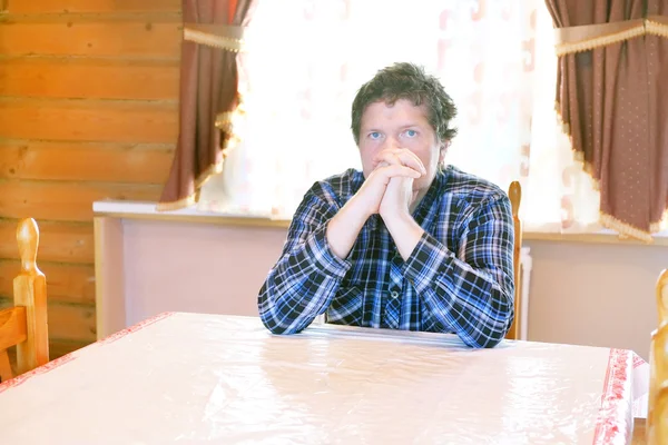 Hombre sentado en una mesa — Foto de Stock