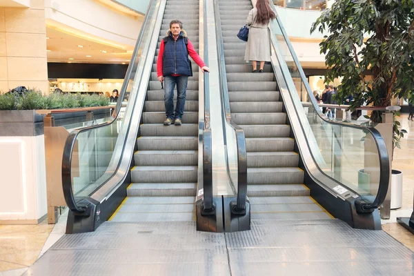Hombre en la escalera mecánica en el centro comercial —  Fotos de Stock