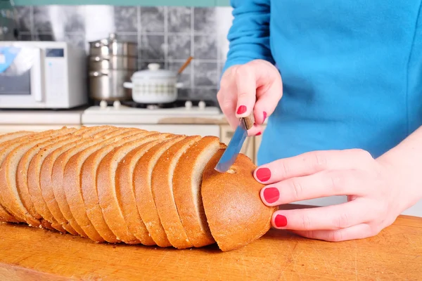 Mãos femininas cortando pão — Fotografia de Stock