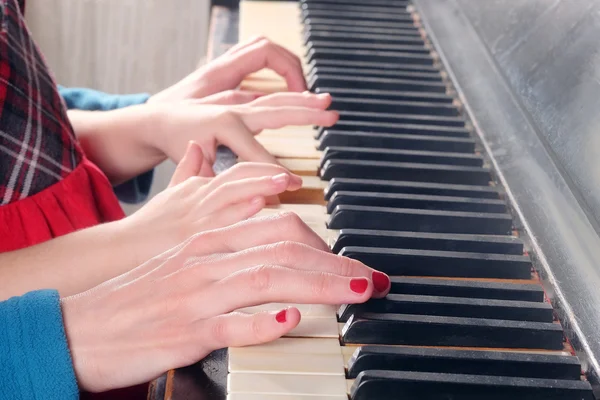 Mãos de pessoas tocando piano — Fotografia de Stock