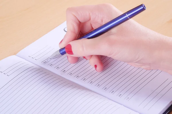 Hand mit Stift und Notizbuch — Stockfoto