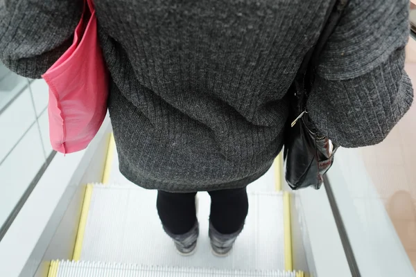 Mujer usando la escalera mecánica — Foto de Stock