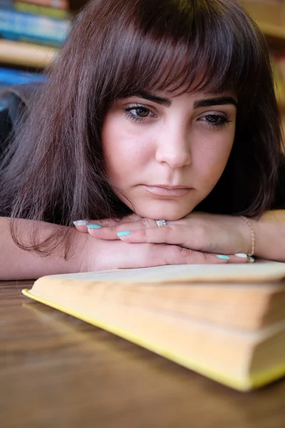 Tired girl student at a library — Stock Photo, Image