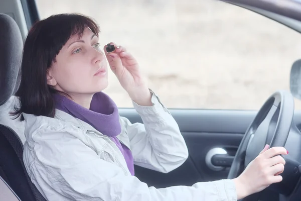 Woman wearing eyeliner in  car — Stock Photo, Image