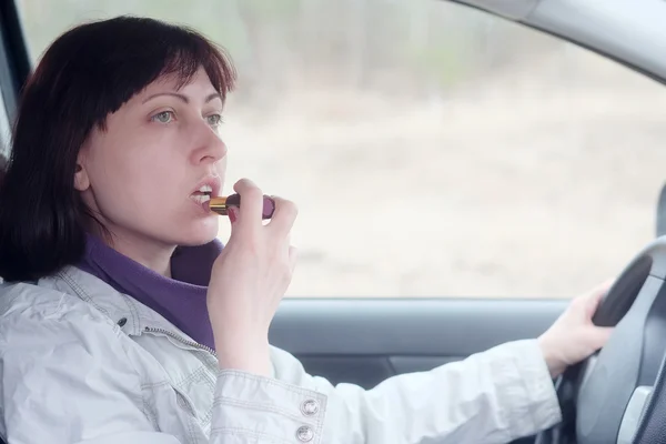 Woman make up lips in car — Stock Photo, Image