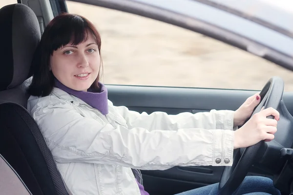 Mujer sentada detrás del volante — Foto de Stock