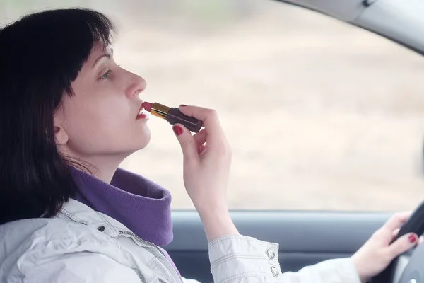 Women make up lips at  wheel — Stock Photo, Image