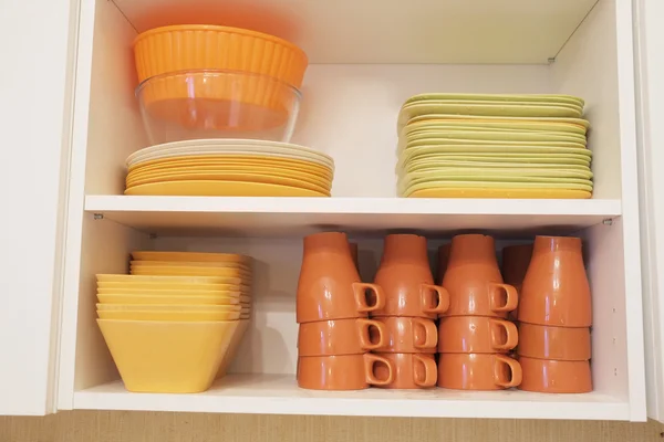 A polcokon színes tányérok és csészék — Stock Fotó