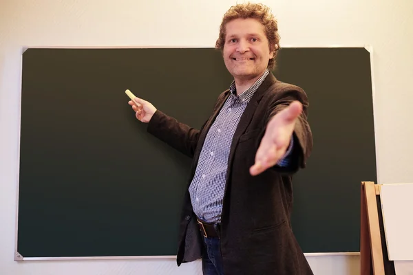 Male teacher writes on blackboard — Stock Photo, Image