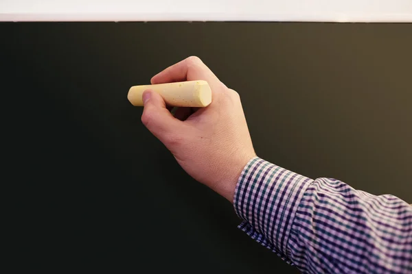 Male hand writing on a blackboard — Stock Photo, Image