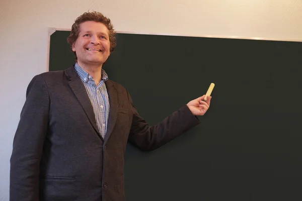 Male teacher writes on blackboard — Stock Photo, Image