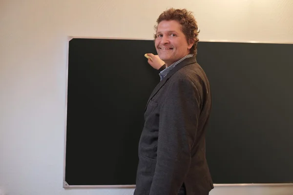 Male teacher writes on blackboard — Stock Photo, Image