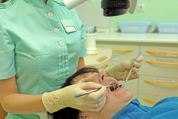 Dentista curando a una paciente mujer —  Fotos de Stock