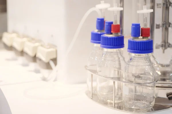 Бутылки с химикатами в лаборатории — стоковое фото