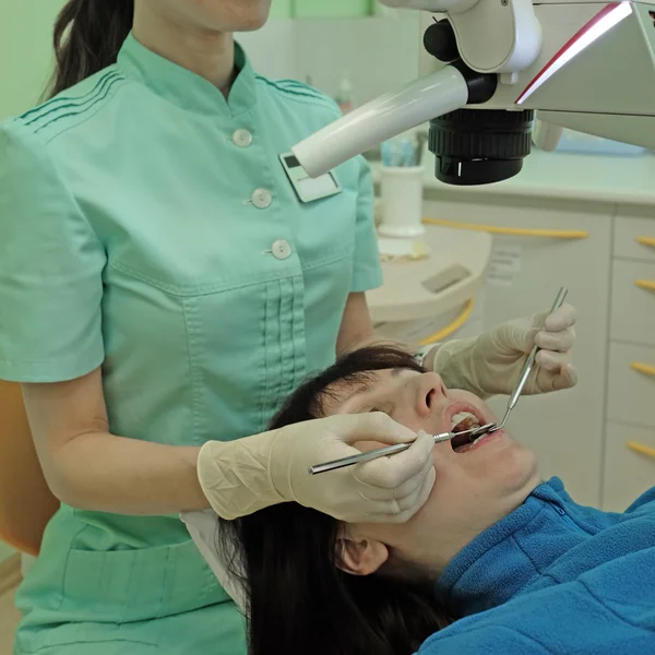 Dentista curando uma paciente mulher — Fotografia de Stock