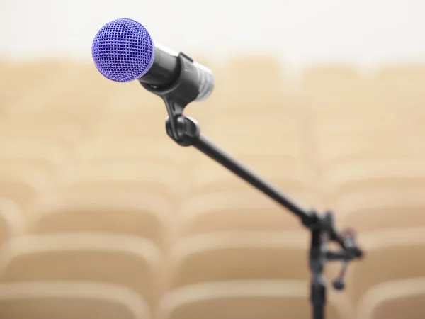 Microfone e auditório desfocado — Fotografia de Stock