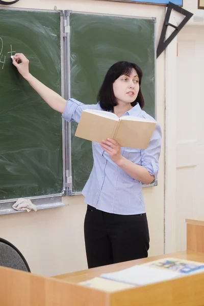 Teacher stands at  blackboard — Stock Photo, Image