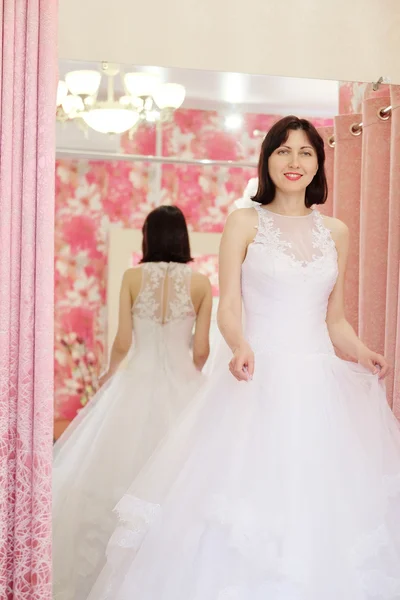 woman tries on  wedding dress