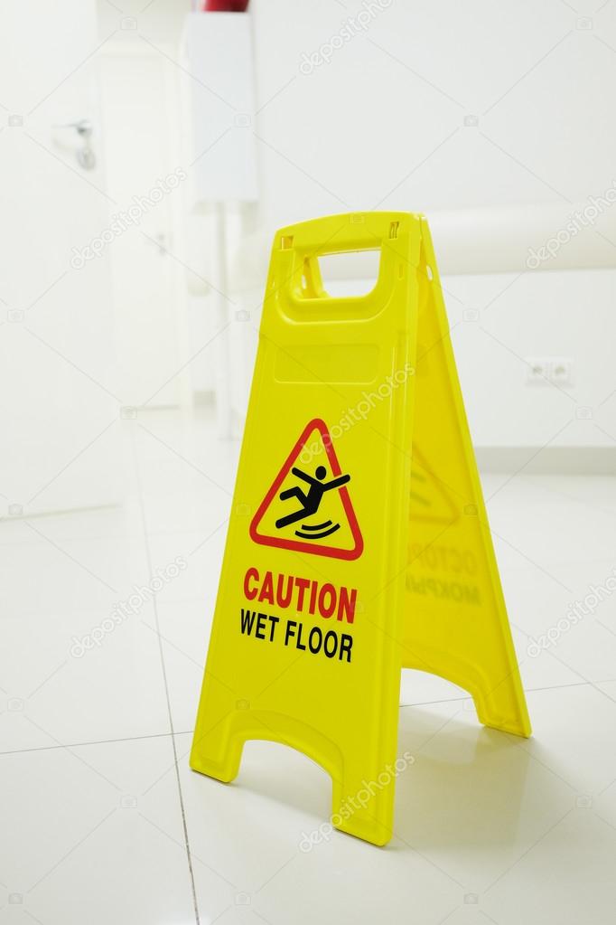 Plate with the warning of a wet and slippery floor