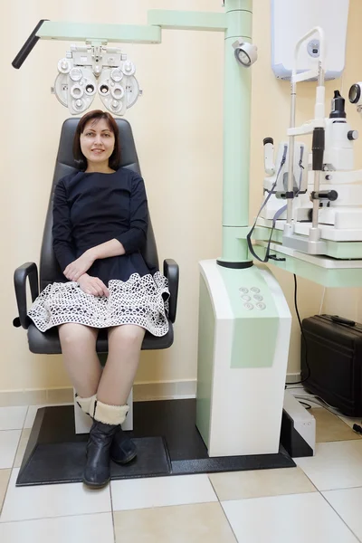 Portrait d'une femme assise derrière le phoropter lors d'un examen oculaire — Photo