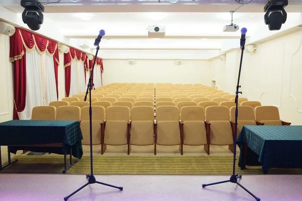 Microfoons en wazig auditorium in de achtergrond — Stockfoto