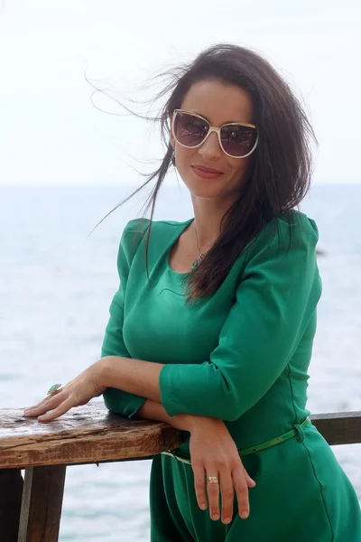 Portret van mooie jonge vrouw permanent op het strand op zoek op zee — Stockfoto