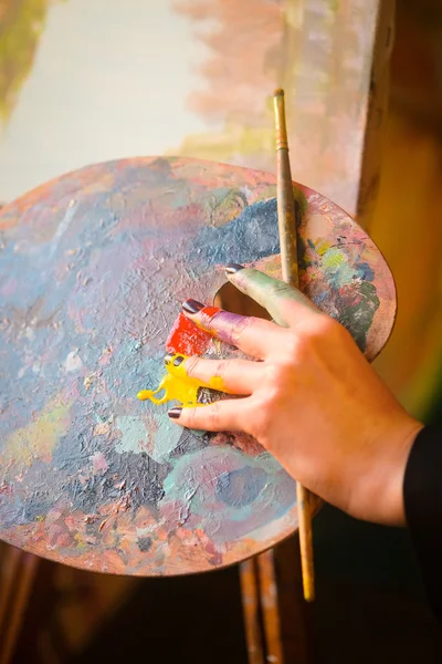Рука художника с кисточками — стоковое фото