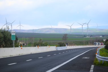 arka plan altında otoyol ve rüzgar türbinleri