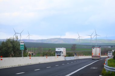 arka plan altında otoyol ve rüzgar türbinleri