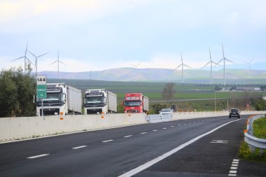 arka plan altında otoyol ve rüzgar türbinleri
