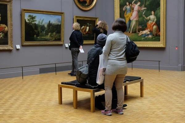 Посетители смотрят на фотографии в Лувре — стоковое фото