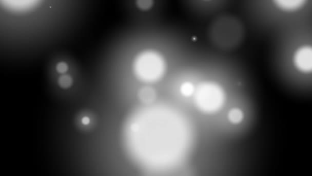 Wazig zwart-wit abstracte video bokeh van knipperende gedefocuste vakantie lichten op donkere achtergrond. — Stockvideo